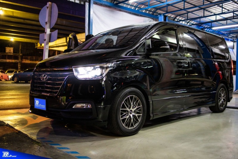 A sleek and modern black van parked in a well-lit area, representing a limousine service that offers comfort and safety.