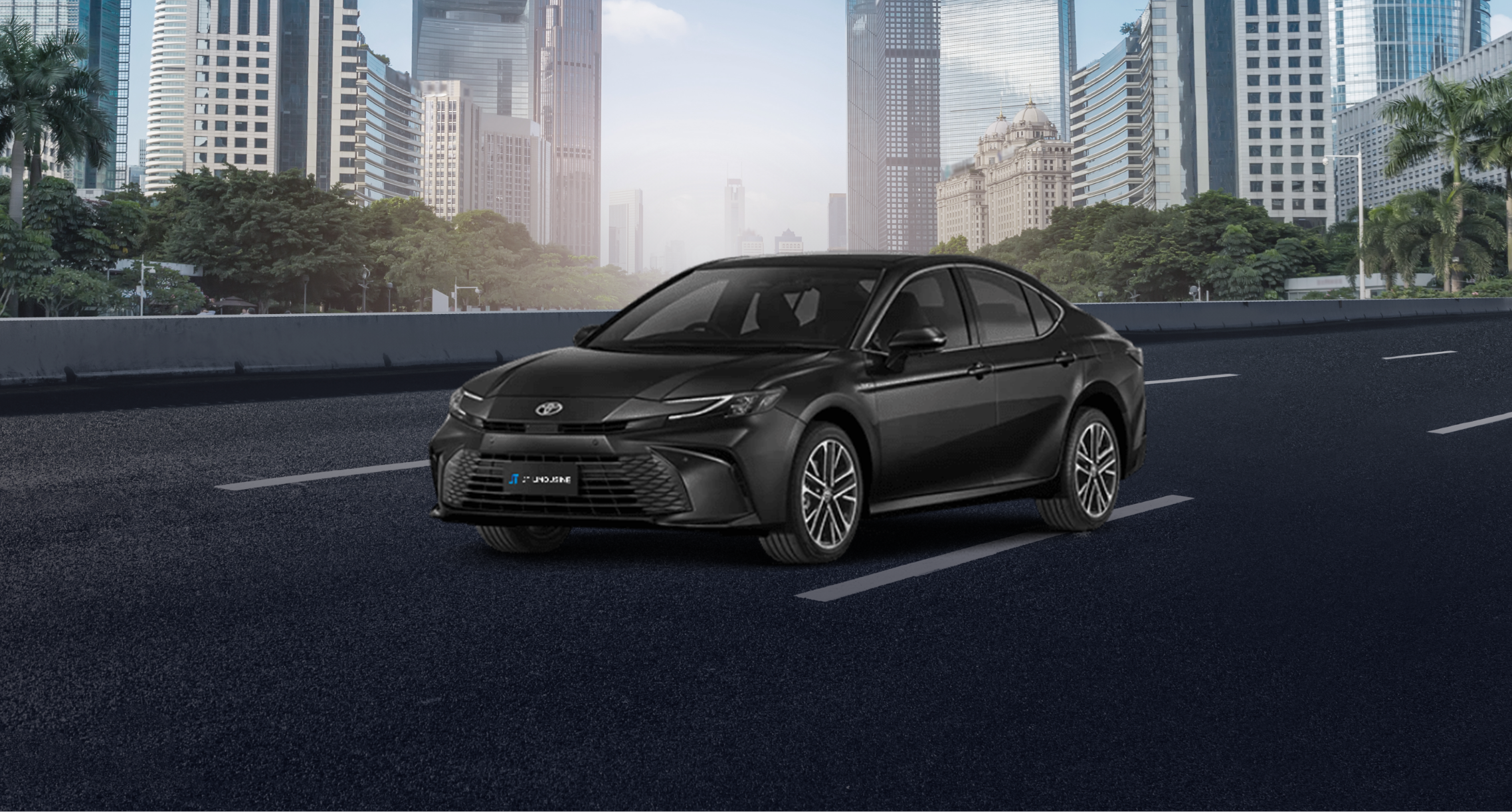 A sleek black Toyota Camry sedan parked on a city street, with modern high-rise buildings and lush greenery in the background. The car's stylish and elegant design suggests it’s well-suited for urban commuting or premium transportation services.