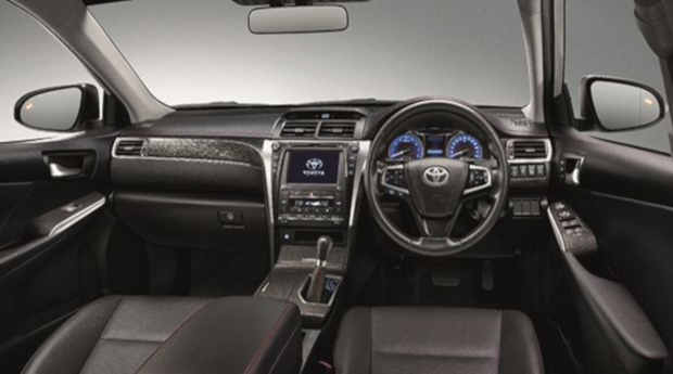 The interior of a luxury car featuring black leather seats with white stitching, a modern dashboard with a digital display, and a gear shifter on the center console. The overall design conveys a sense of premium comfort and advanced in-car technology.