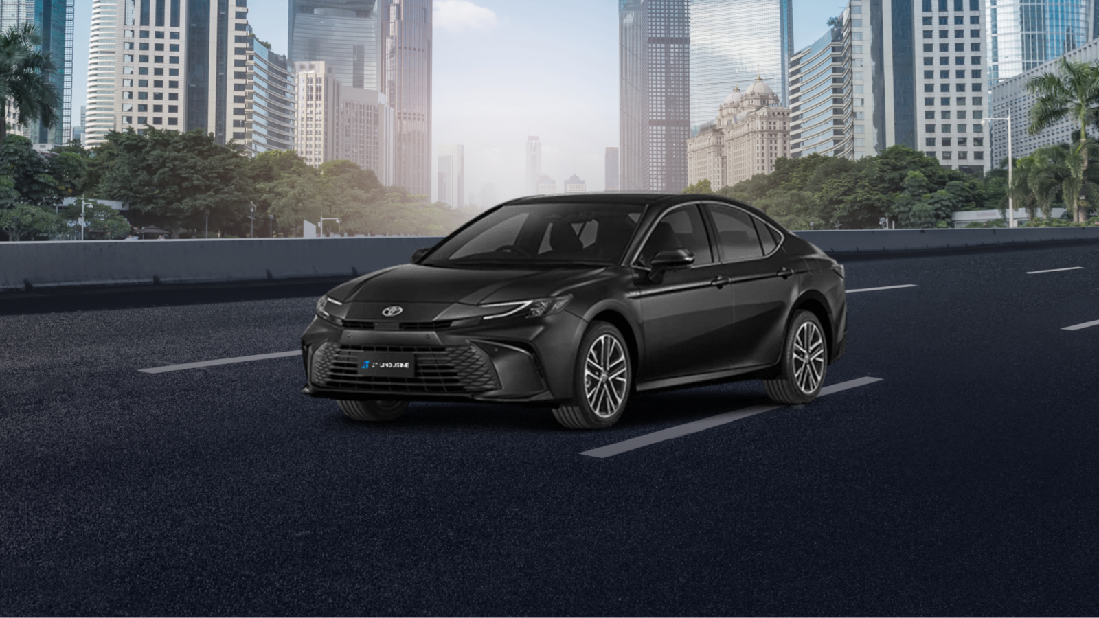 A sleek black Toyota Camry sedan parked on a city street, with modern high-rise buildings and lush greenery in the background. The car's stylish and elegant design suggests it’s well-suited for urban commuting or premium transportation services.