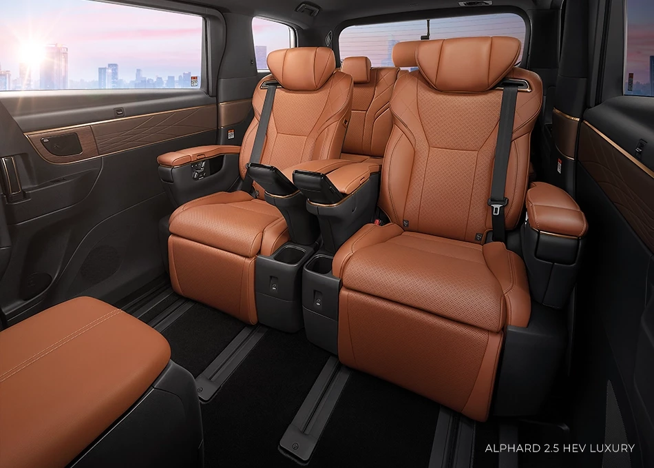 Interior of a luxurious limousine, Alphard 2.5 HEV Luxury model, featuring light brown leather reclining seats with armrests and cup holders.