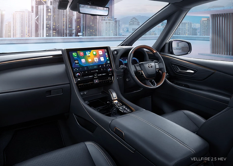 Interior of a Vellfire 2.5 HEV car, featuring luxurious and modern design, suitable for limousine services. It includes a large touchscreen displaying various applications, a leather-wrapped steering wheel, and comfortable seats.